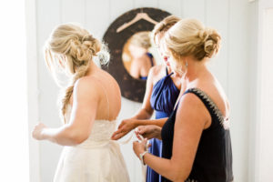Bride getting into gown. Photographed by Morgan Williams Photography.