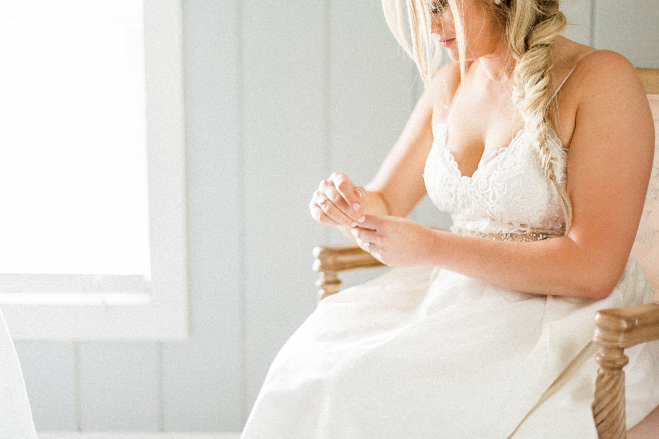 Bride putting on jewelry. Photographed by Morgan Williams Photography.